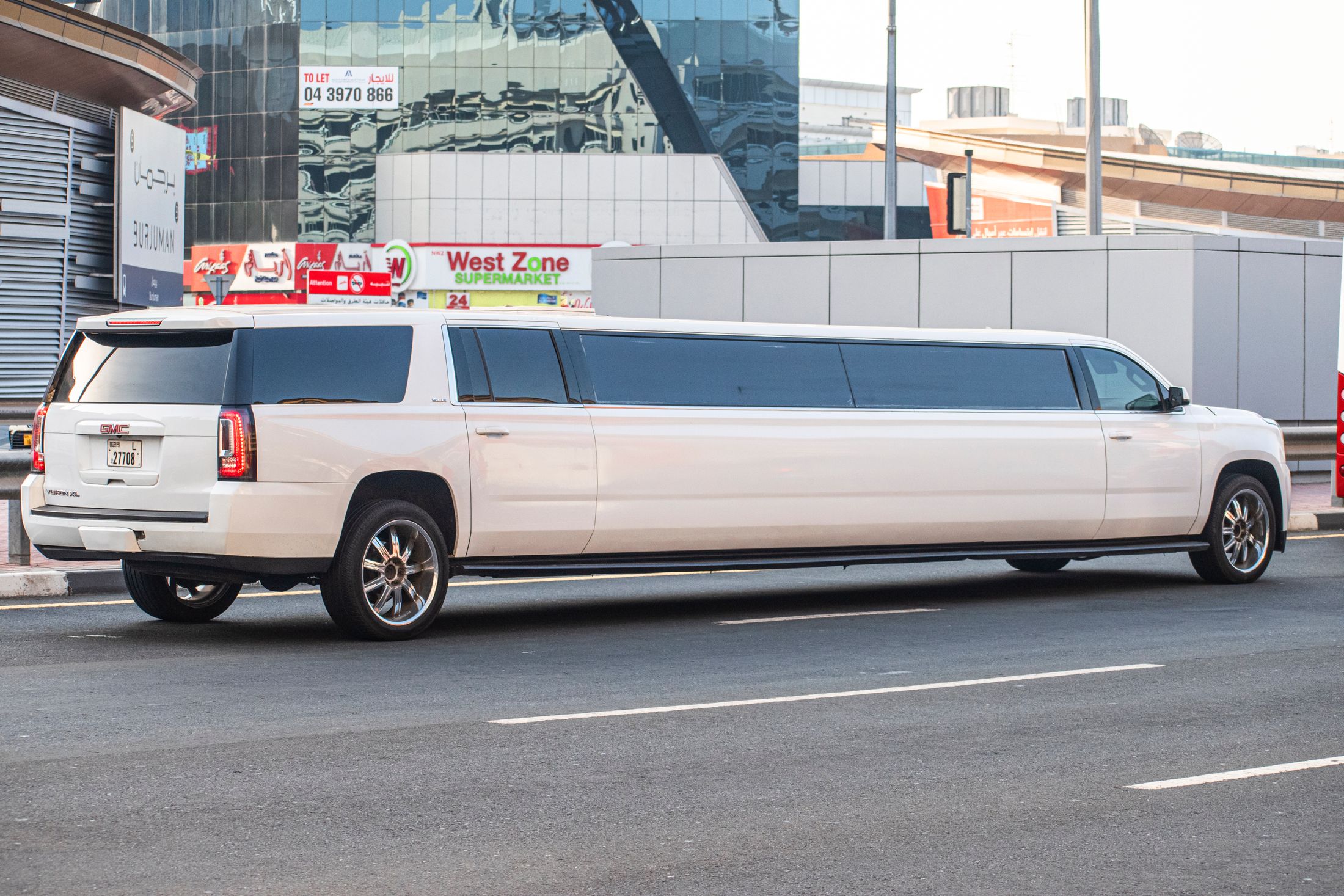 Full side view of a white SUV stretch limousine